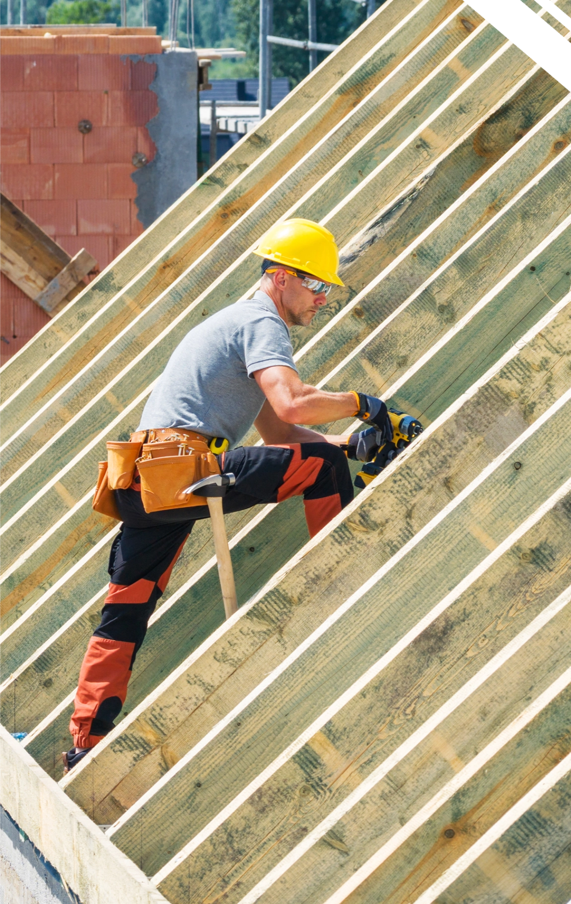 Cieśla montujący drewnianą więźbę dachową na stelażu dachu – Ciesielstwo