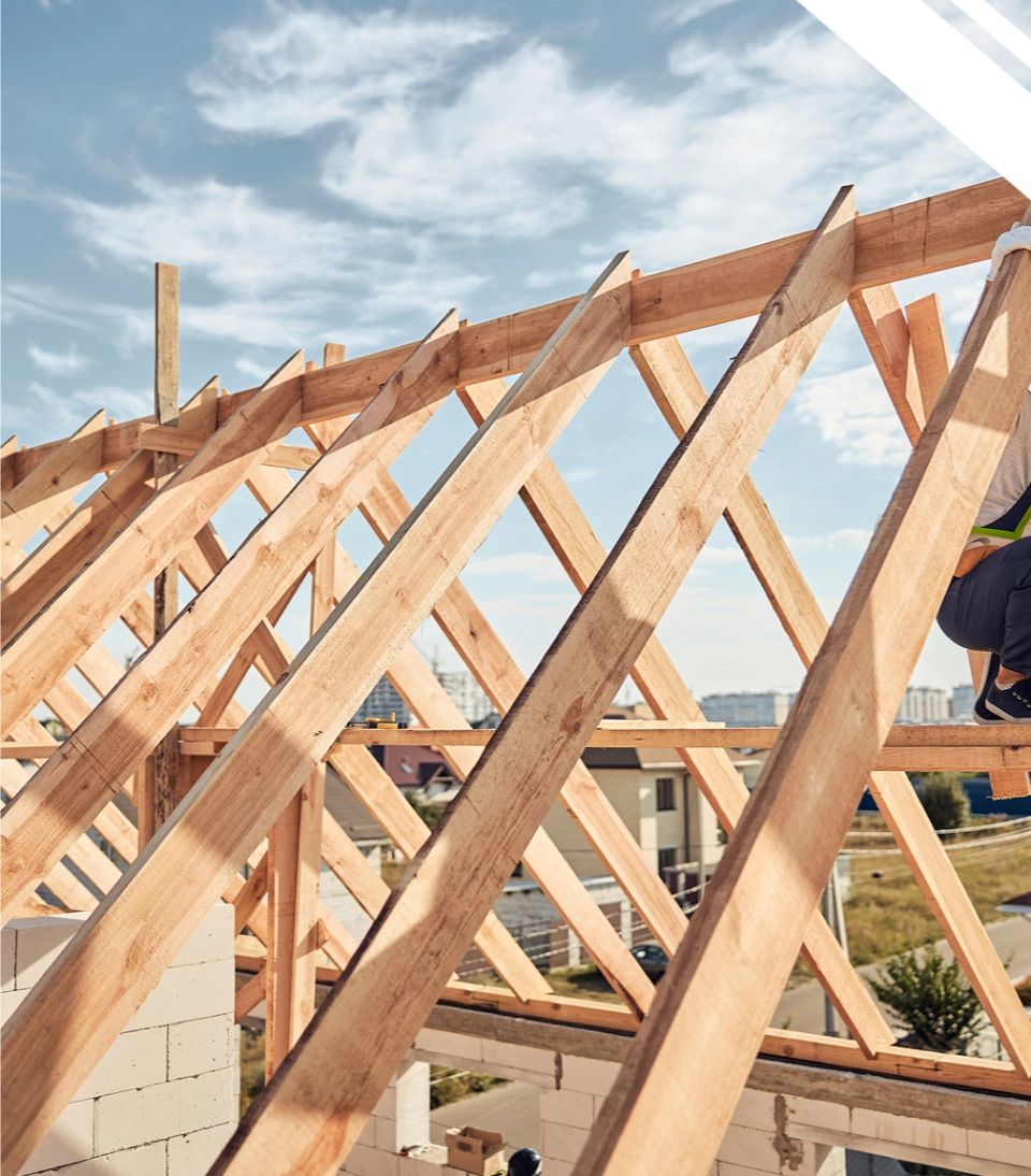 Montaż drewnianych wiązarów dachowych tworzących konstrukcję więźby na budowie